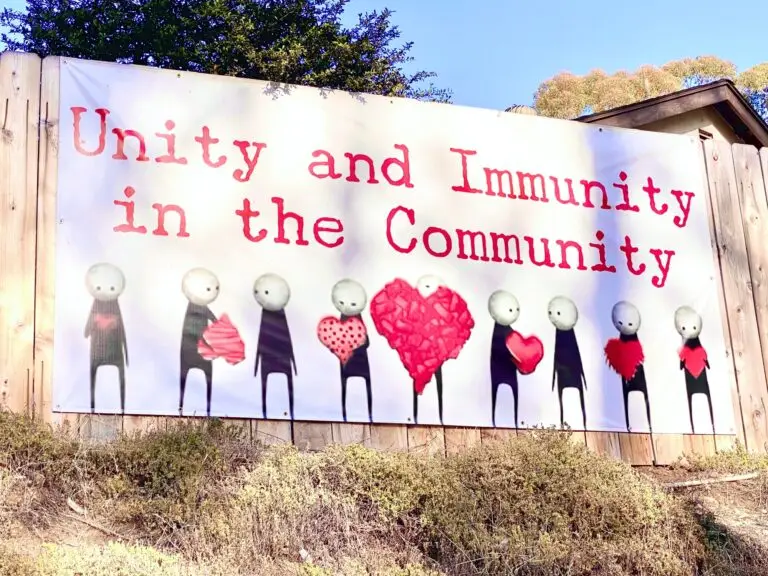 Authentic real community banner sign calling for unity and immunity in the community